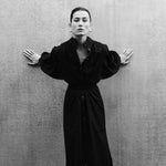 Woman wearing MAY black cotton voile dress with hand-embroidered sculptural sleeves, minimal elegant design