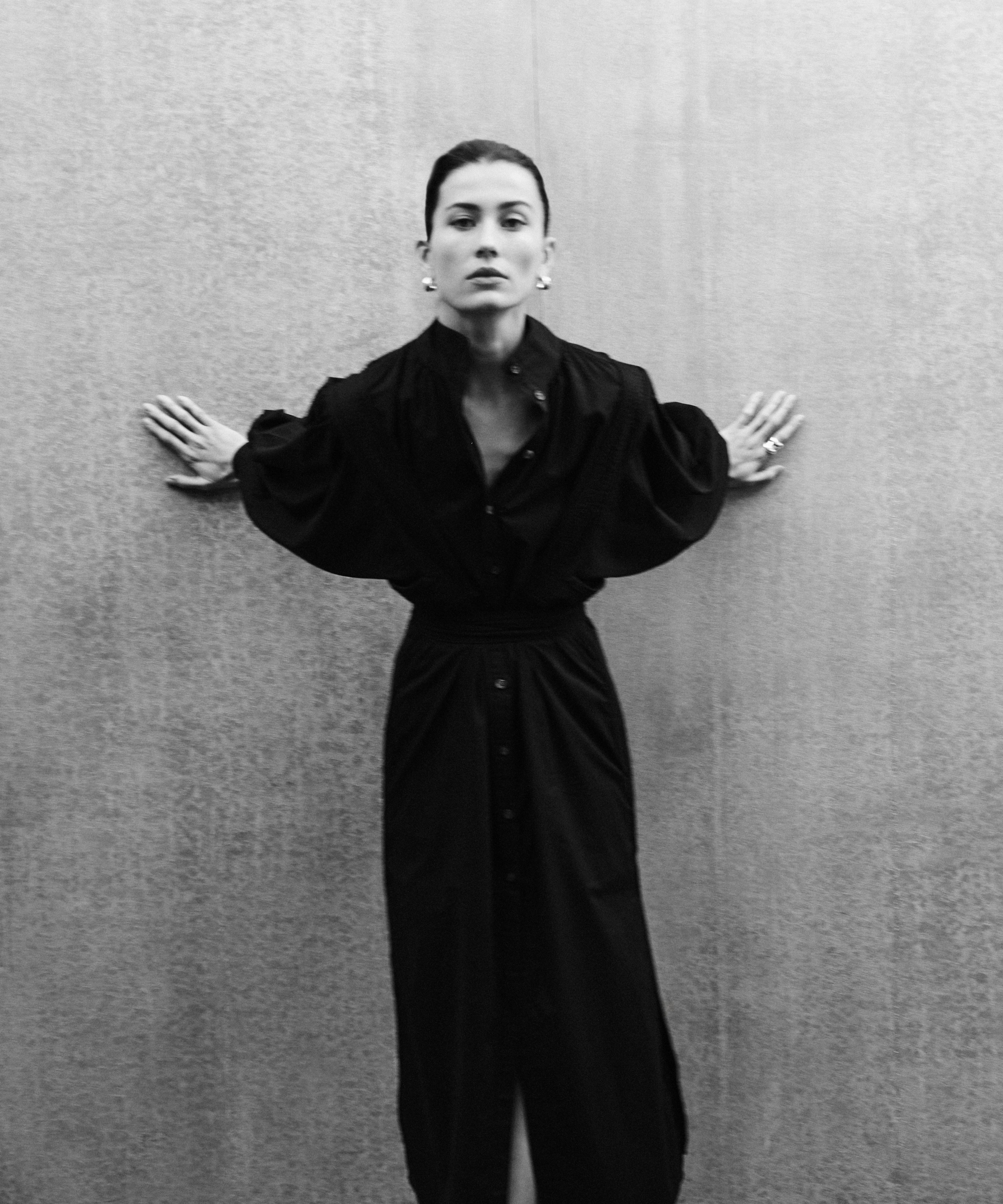 Woman wearing MAY black cotton voile dress with hand-embroidered sculptural sleeves, minimal elegant design
