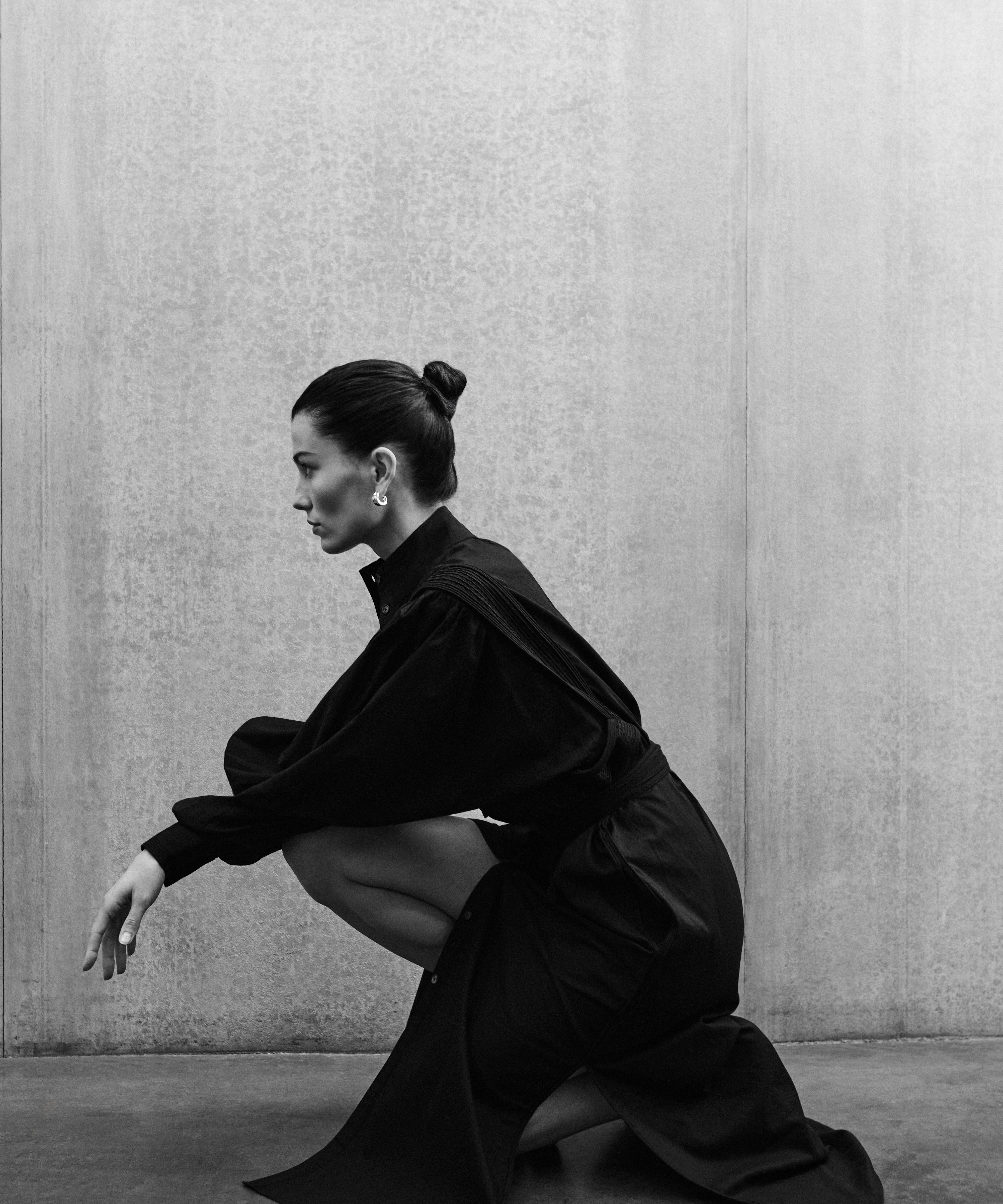 Woman in black MAY dress with artisanal hand-embroidered details, premium cotton voile, minimalist luxury fashion by Aymone Studio