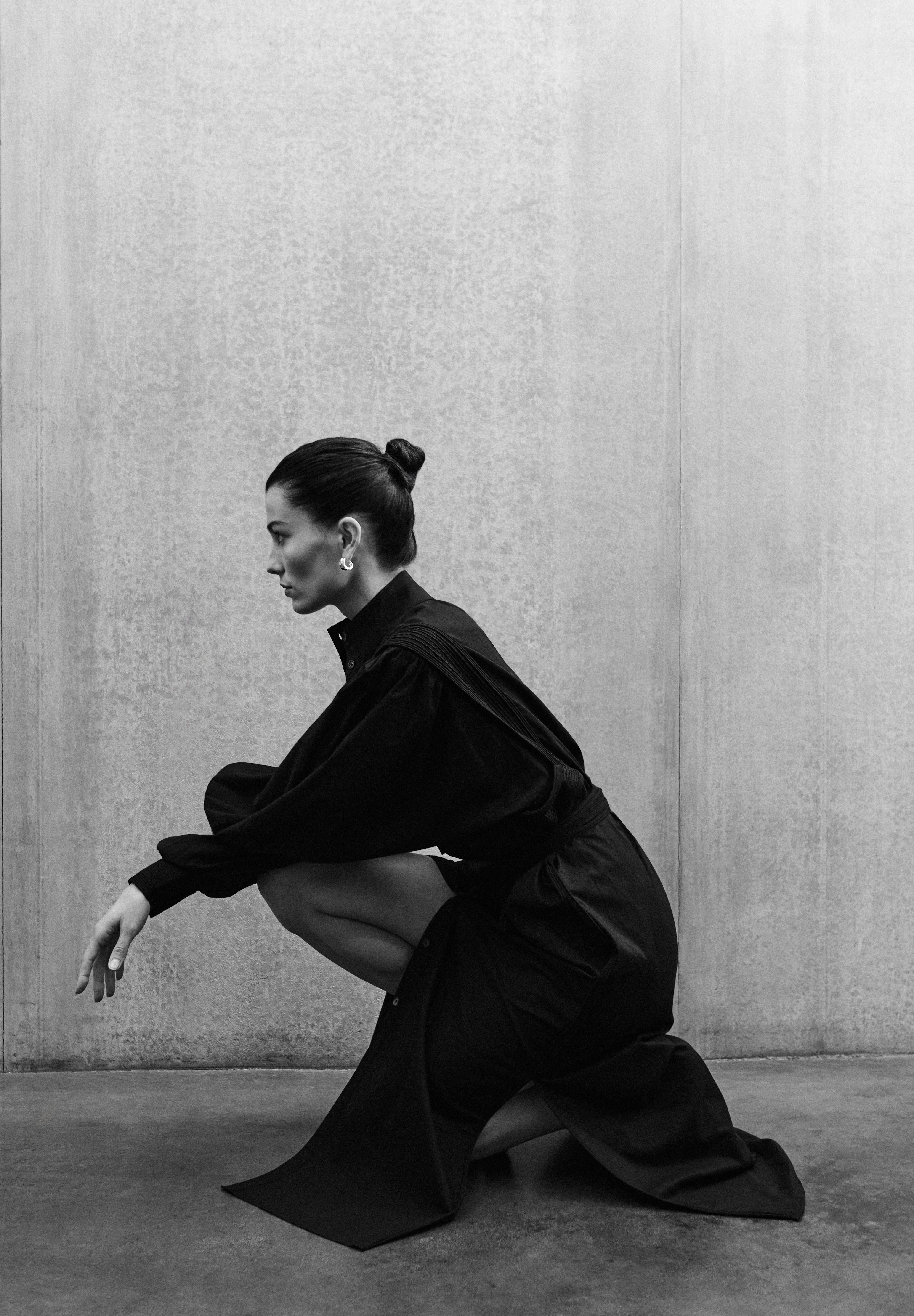 Woman in black MAY dress with artisanal hand-embroidered details, premium cotton voile, minimalist luxury fashion by Aymone Studio