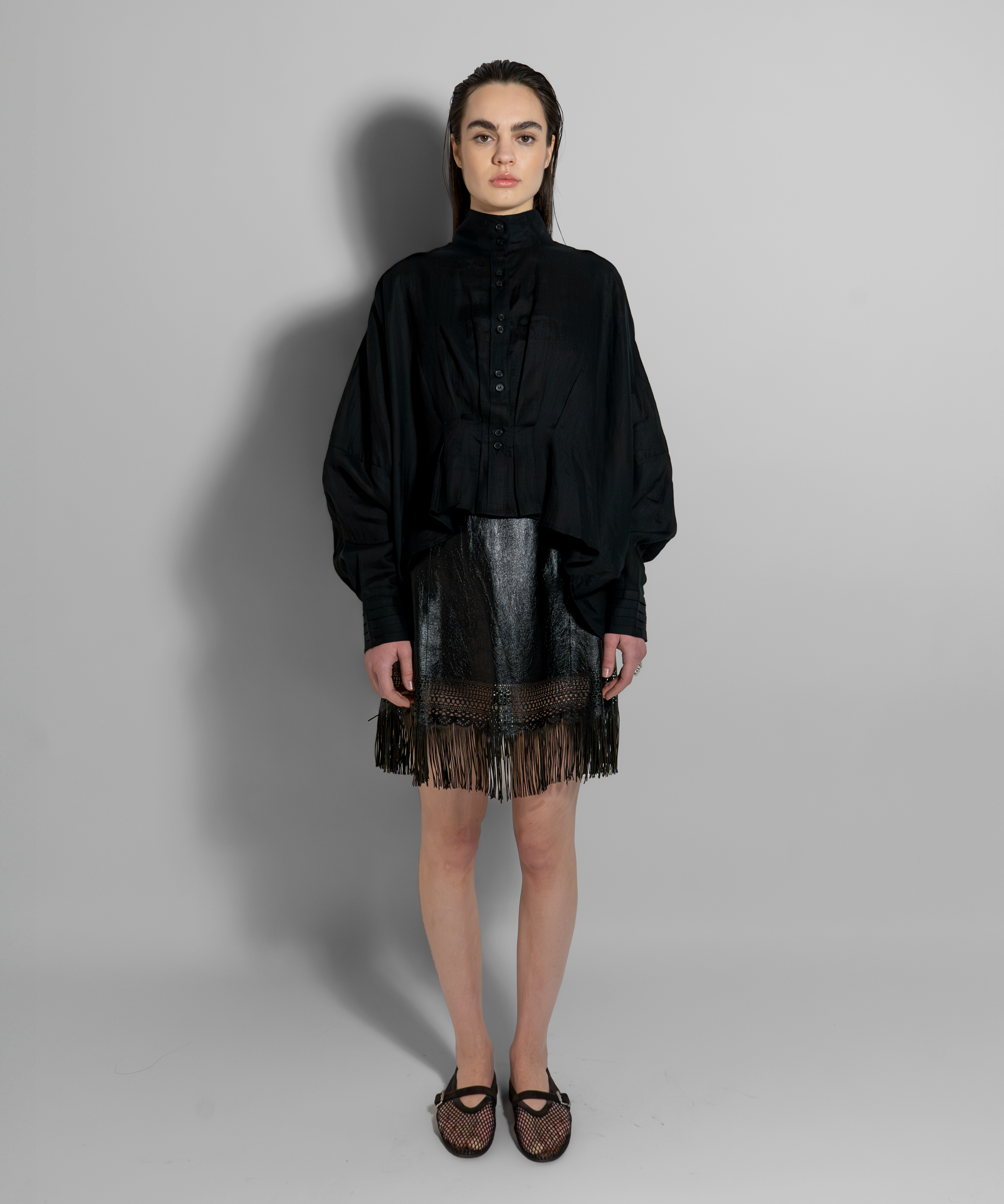 Black CATE luxury linen shirt worn with metallic fringe skirt, showcasing Aymone Studio's minimalist elegance and sculptural design aesthetic