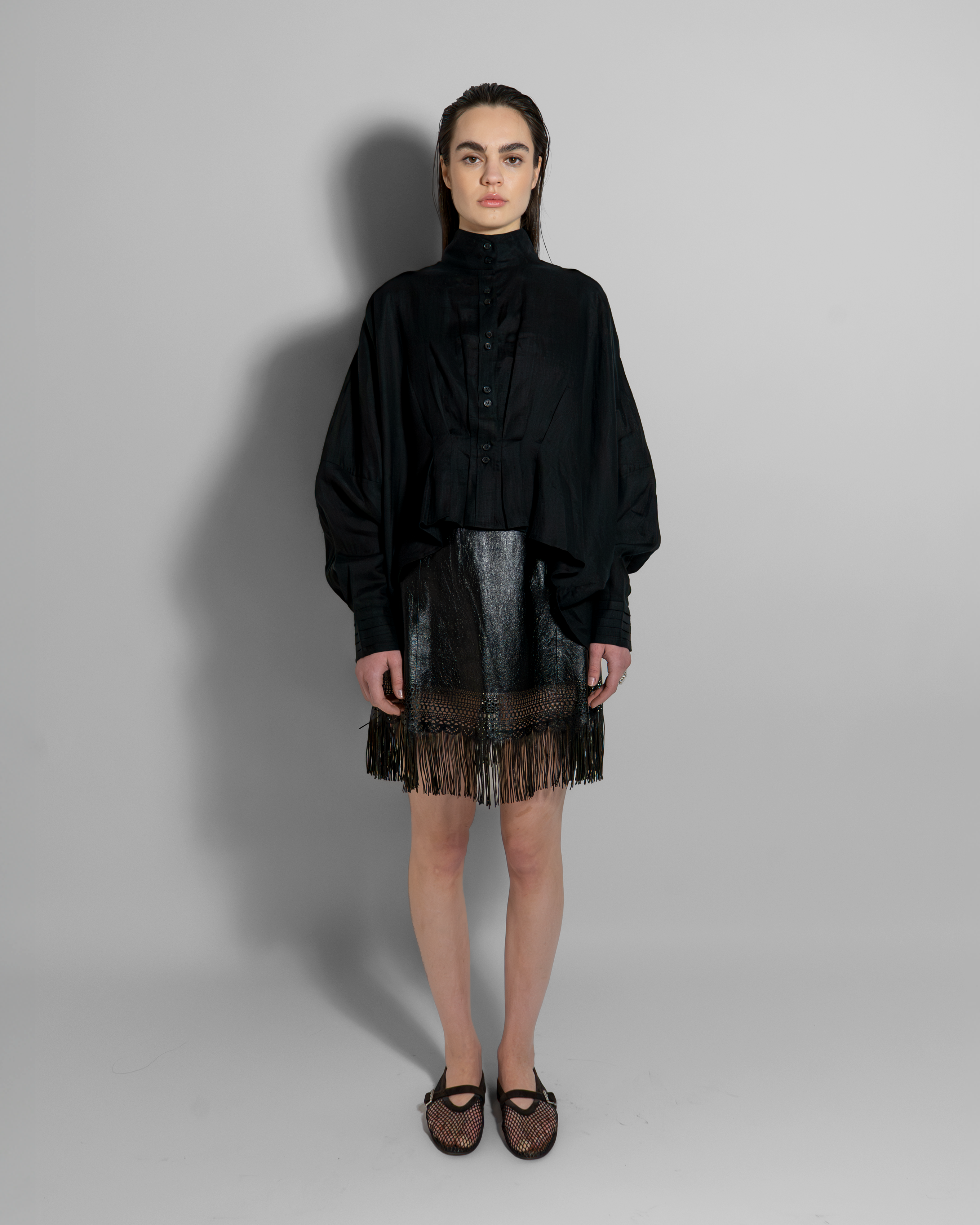 Black CATE luxury linen shirt worn with metallic fringe skirt, showcasing Aymone Studio's minimalist elegance and sculptural design aesthetic