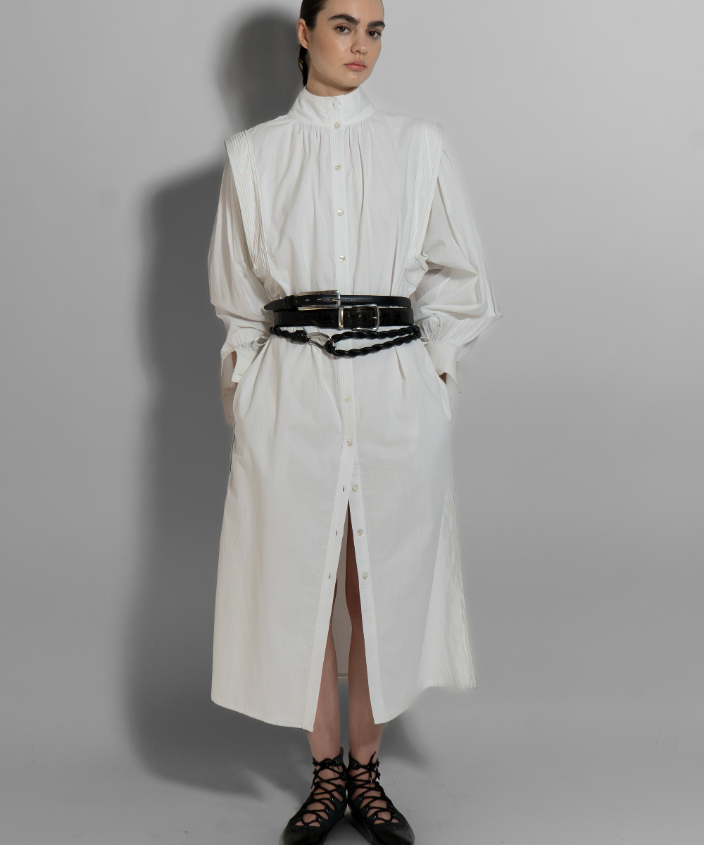 White cotton voile MAY dress with hand-embroidered details, black belt, long sleeves, and architectural cut for modern minimalist style