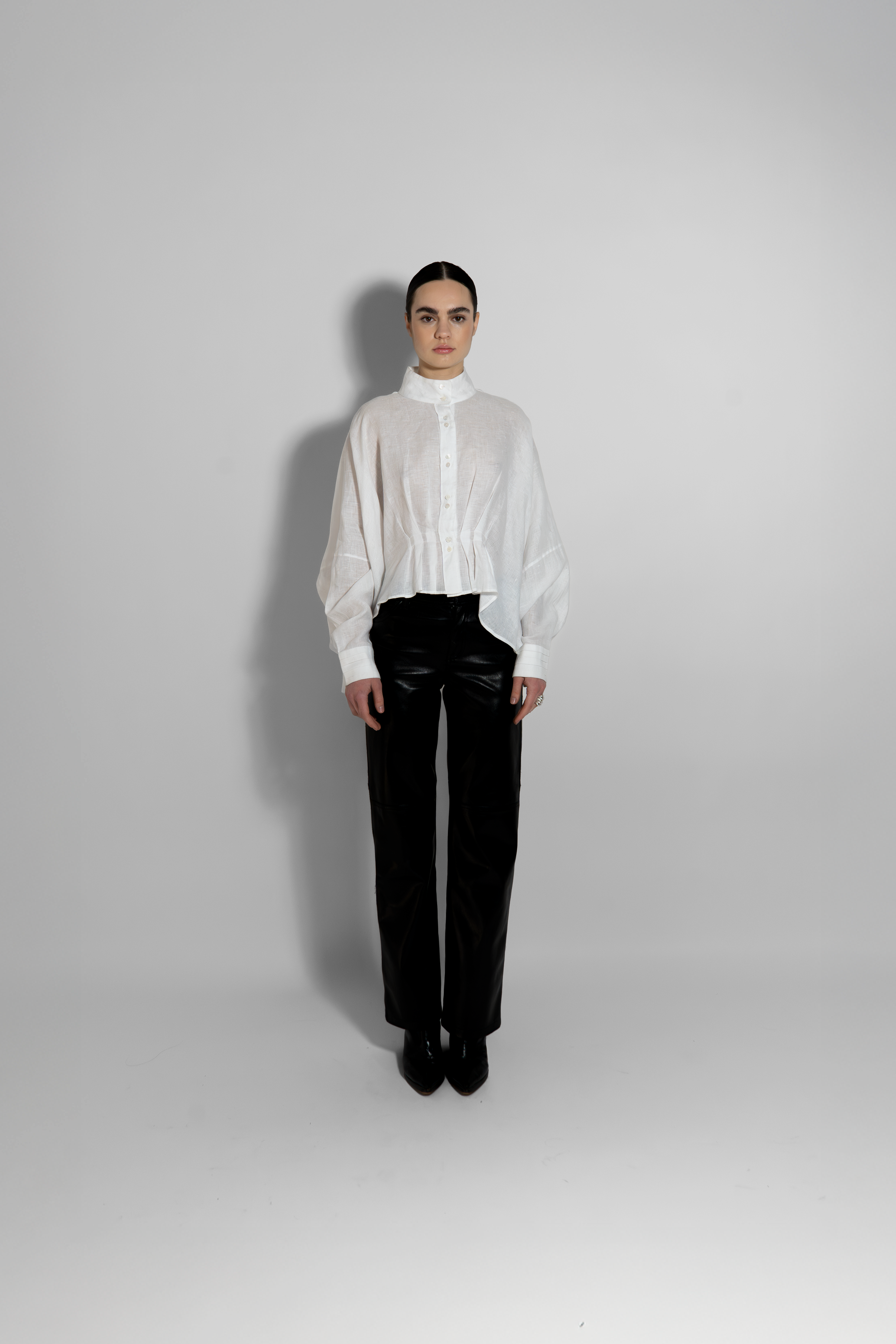 White linen shirt with high neckline and tailored black pants full look