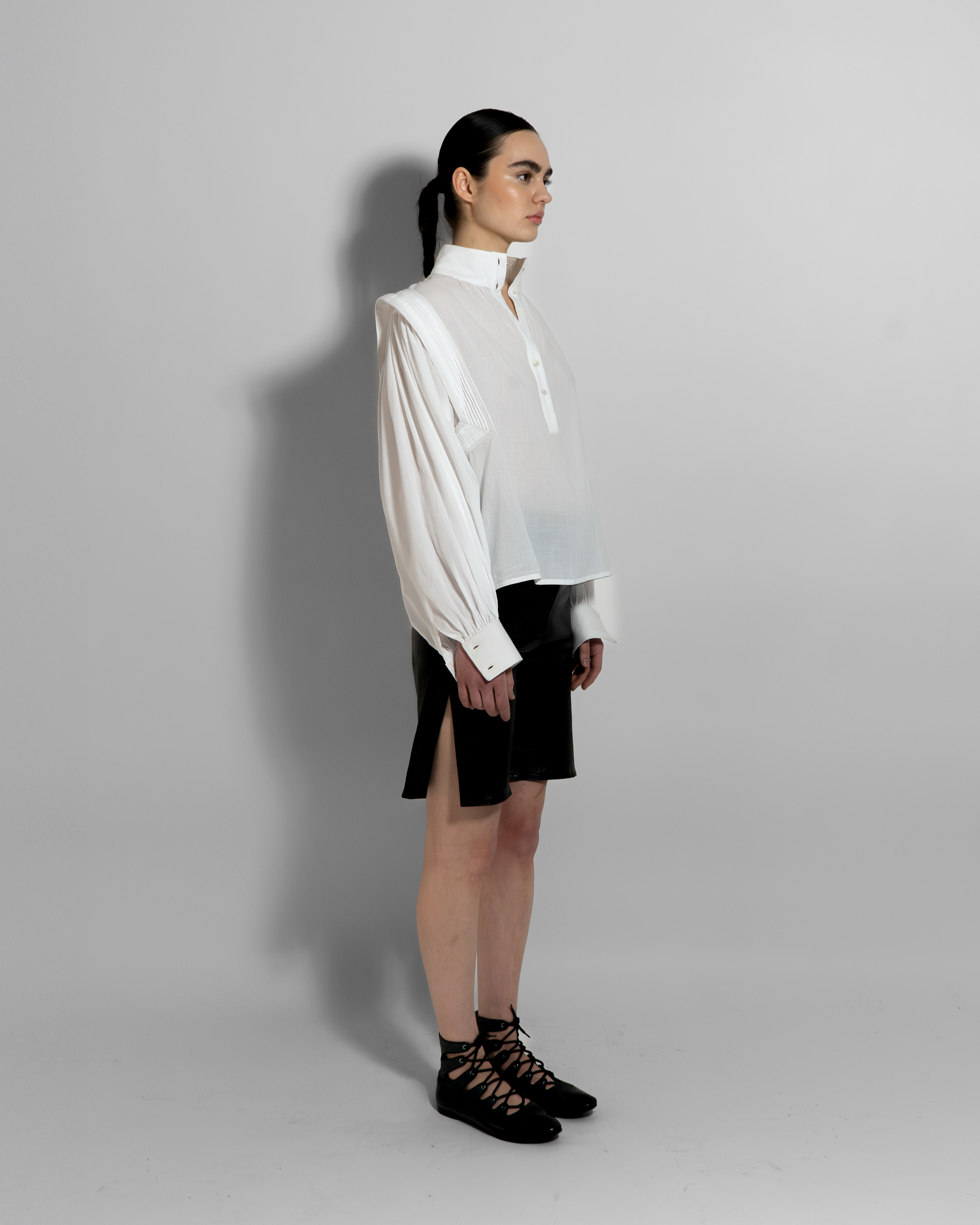 MAY white cotton voile blouse with sculptural oversized sleeves and hand-stitched details, paired with black shorts